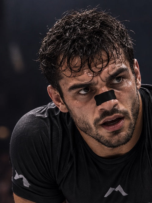 Close-up of a grappler between exchanges, breathing through a black CombatStrips nose strip